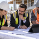 Construction team reviewing submittals, project records and plans during site administration