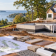 A Maryland homeowner and estimator review site plans, drainage, utility connections, and finish materials beside a house under construction.