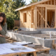 Builder and homeowner reviewing plans for a backyard guest house under construction