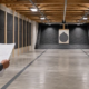 Builder reviews plans for a safe indoor target range with acoustic wall panels and a clear backstop.