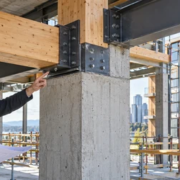 Engineers inspect a hybrid steel, timber and concrete frame for composite building construction.