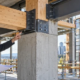 Engineers inspect a hybrid steel, timber and concrete frame for composite building construction.
