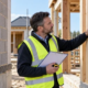 Inspector compares brick, timber-frame and steel-frame wall sections at a residential construction site.