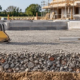 Compacted hardcore crushed-stone base being prepared beneath a new building foundation