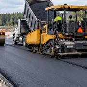Hot-mix asphalt is laid by a paver and compacted by a roller to form a smooth, durable road wearing course.