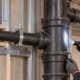 Cast iron drainage stack with supported hub-and-spigot joints being inspected in a building plumbing system.