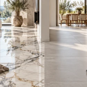 Marble and porcelain tile flooring samples side by side in a sunlit modern living room.