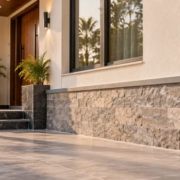 Contractor checks the alignment of protective stone cladding along the lower exterior wall of a home.