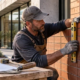 Mason checking the aligned vertical joints of a stacking bond brick wall with a level