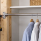 Carpenter secures a closet rod support bracket to wall framing before the pole carries hanging clothes.