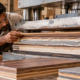 Engineer inspects bonded layers of engineered wood under a press to illustrate construction laminating