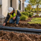 Roof gutter and downspout connected to a buried rainwater leader pipe carrying runoff toward a storm drain.