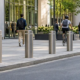 Steel bollards protect pedestrians along a sidewalk outside a public building