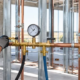 A plumbing technician monitors a pressure gauge during a water pipe test before the walls are closed.