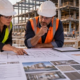 An owner and contractor review a guaranteed maximum price scope, subcontract quotes, contingency, and schedule on commercial project plans.