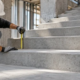 Construction worker measuring a concrete stair riser with a tape measure