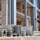 Construction worker inspects extruded aluminum profile sections used in a modern building facade.