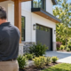 Home appraiser inspects a newly built house while comparing nearby home sales on a tablet.