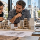 Architects and engineers compare building models and material samples to balance urban space, structural needs, and sustainability.
