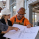 An engineer, architect, and plumbing contractor review a building section drawing to clarify a project detail before work proceeds.