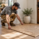 Contractor placing a compact 3-by-2-foot woven rug on the finished floor of a newly built home.