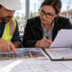 A contractor and project reviewer compare construction progress photos, inspection records, and cost documents for a loan draw request.