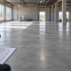 Estimator measuring a concrete floor with a laser meter and project plan