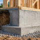 Concrete stem wall connecting a raised house foundation to the framed exterior walls