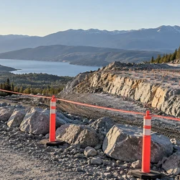 Construction supervisor maintaining a safe exclusion zone at a controlled rock excavation site