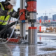 Worker using a core drill to bore a clean opening through a concrete slab