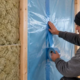 Vapor-control membrane installed behind insulation in a framed exterior wall