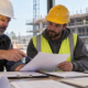 Contractor and subcontractor reviewing construction lien payment records at a jobsite