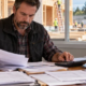 Construction business owner reviewing indirect operating expenses and project plans