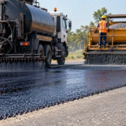 Road crew applying asphalt emulsion, spreading aggregate, and compacting a protective seal coat