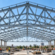 Engineer reviews a triangulated steel roof truss designed to distribute building loads through connected diagonals