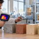 Engineer measures heat response across concrete, brick, timber and insulation samples with a thermal camera.