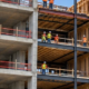 Apartment construction reveals concrete, steel and timber structural sections across a multistory residential frame.