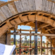 Mason and architect inspect a curved stone arch under temporary support, illustrating arch construction and its structural form.