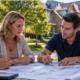 Homeowners and an architectural control committee member review renovation plans beside a residential street, illustrating community design approval.