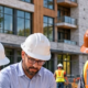 Architect, engineer, and contractor compare coordinated plans and a building model at an active construction site, aligning design with field work.
