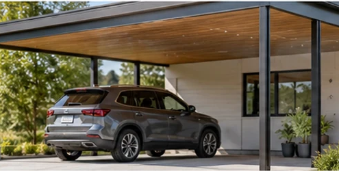 A finished carport attached to a modern home shelters a vehicle beneath a supported roof, showing how the structure connects to the house.