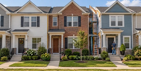 Attached single-family homes share side walls while each unit has its own entrance and a small front yard.