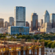 Commercial office tower rises with cranes above the Austin skyline, illustrating the city’s active commercial construction market.