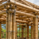 Builders assemble a bamboo house frame with strong bamboo columns and beams joined across the roof and walls.