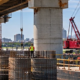 Bridge and waterfront infrastructure crews work beside the Mississippi River in New Orleans, illustrating the city’s major construction projects.