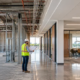 Commercial interior build-out showing unfinished core-and-shell space transitioning to a completed office with walls, lighting, HVAC, flooring, and furnishings.