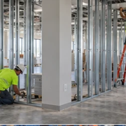 Commercial buildout in progress as a contractor installs interior partitions and ceiling services to turn a shell into a tenant-ready office.