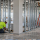 Commercial buildout in progress as a contractor installs interior partitions and ceiling services to turn a shell into a tenant-ready office.