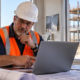 Commercial contractor and estimator compare project plans at a job-site office while preparing a bid for an active building project.