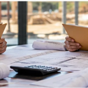 Contractors review proposal folders and construction plans during a commercial pre-bid meeting.